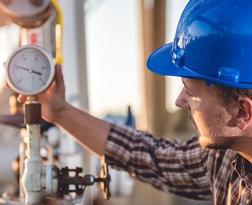 Ein Monteur der eine Gasleitung kontrolliert